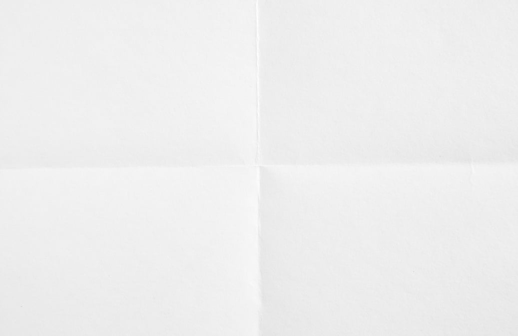 Closeup white blank sheet of paper folded in four. White crumpled paper texture background.